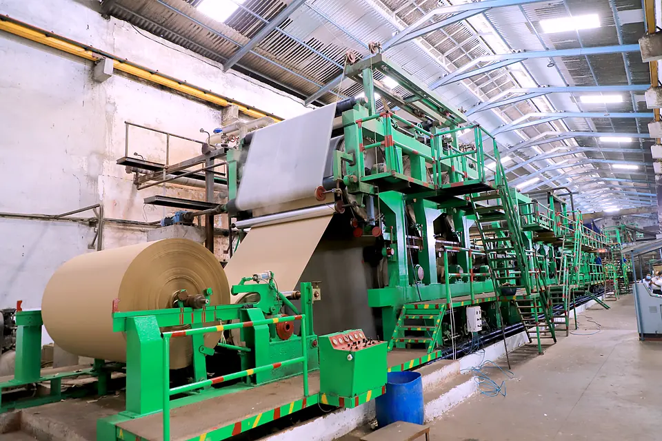 Kraft paper machine at the Jigani Unit 1, with a jumbo reel being lifted